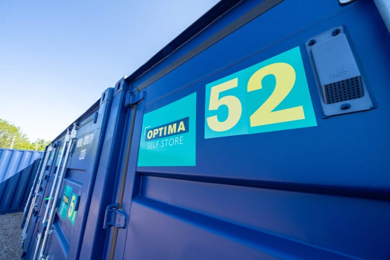 Close-up of a blue Optima Self Store storage container displaying unit number 52 at the Newark facility.