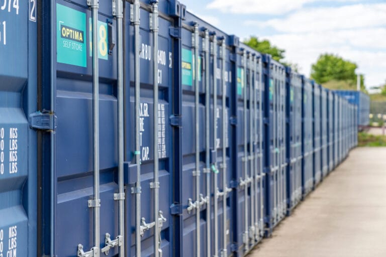 Row of blue Optima Self Store storage containers with numbered doors and an access pathway at the Stamford facility.